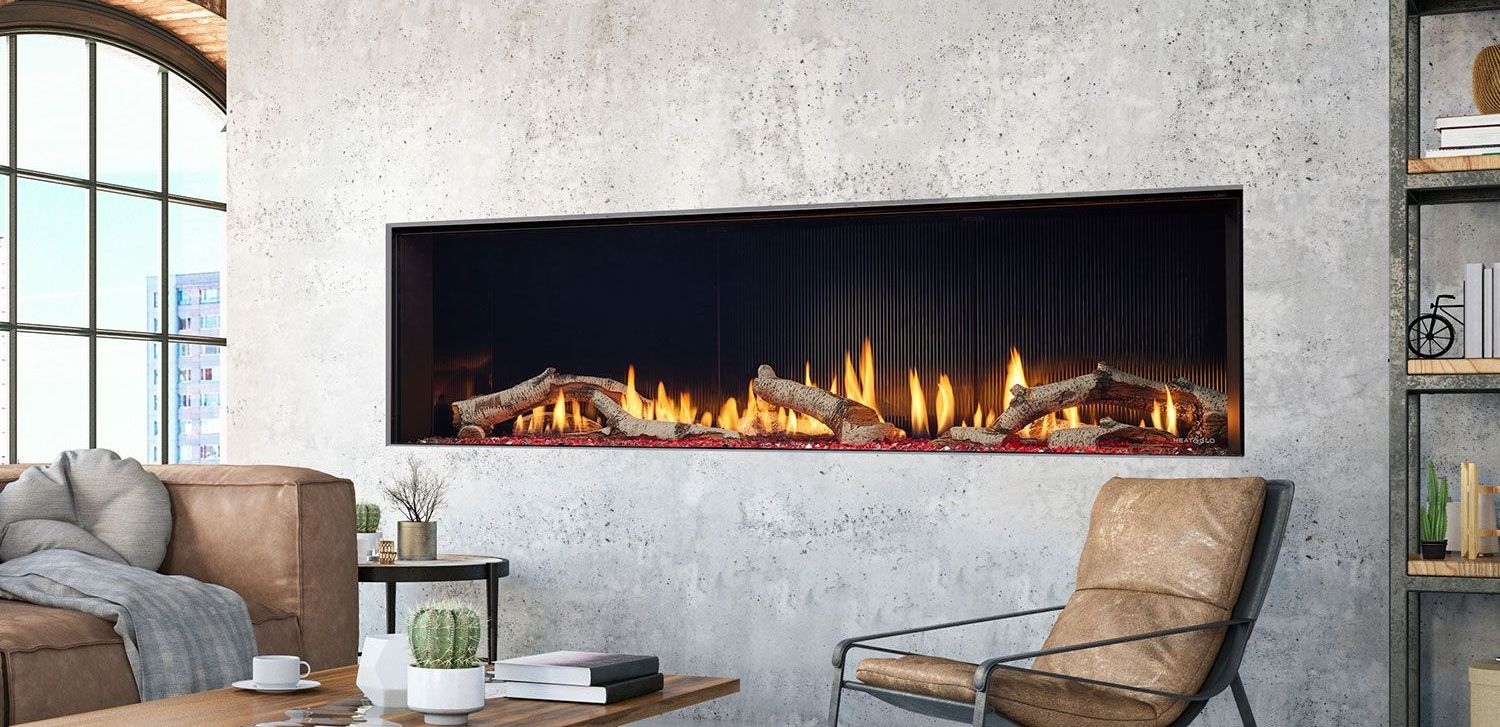 A modern living room with a fireplace embedded in a concrete wall. There's a sofa, chair, and a bookcase.