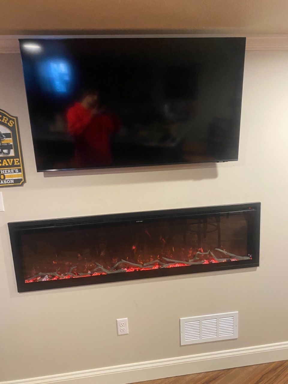 A flat screen tv is mounted above a fireplace in a living room.