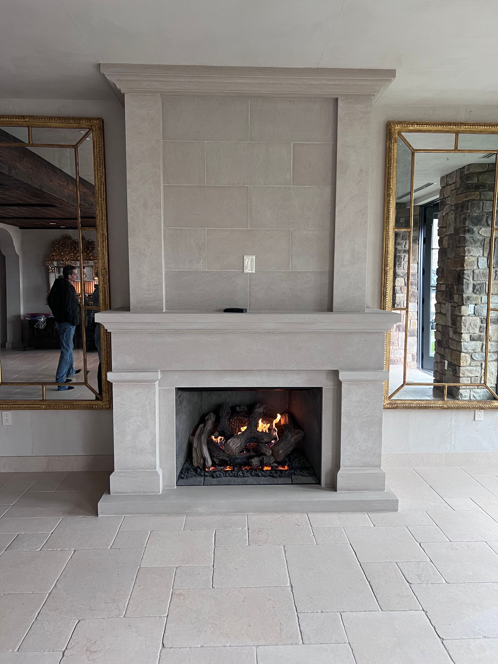 A man is standing in front of a fireplace in a living room.