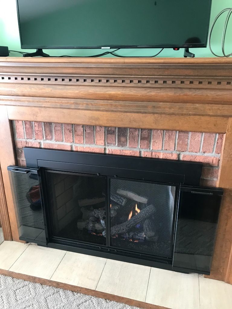 A fireplace with a television on top of it in a living room.