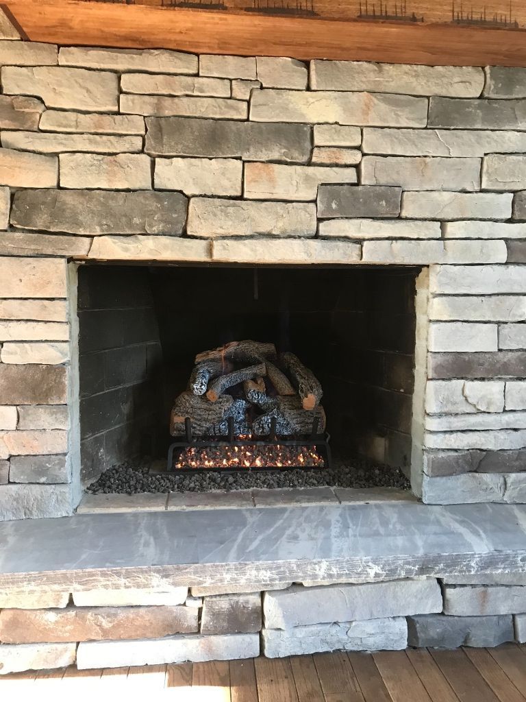 A fireplace with a pile of logs in it.