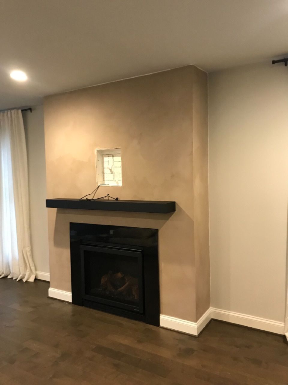 A living room with a fireplace and a clock on the wall.