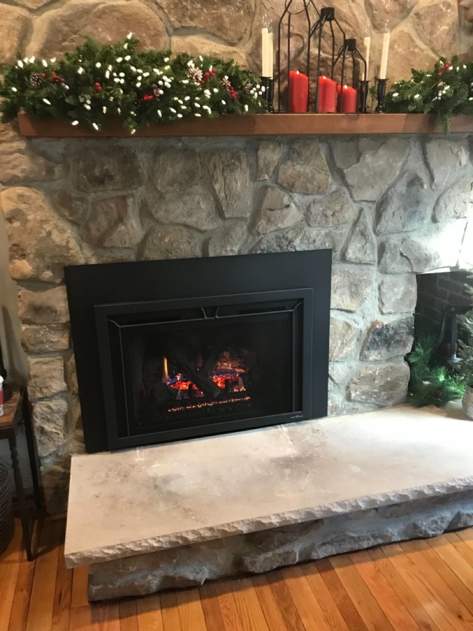 A fireplace in a living room with candles on the mantle.