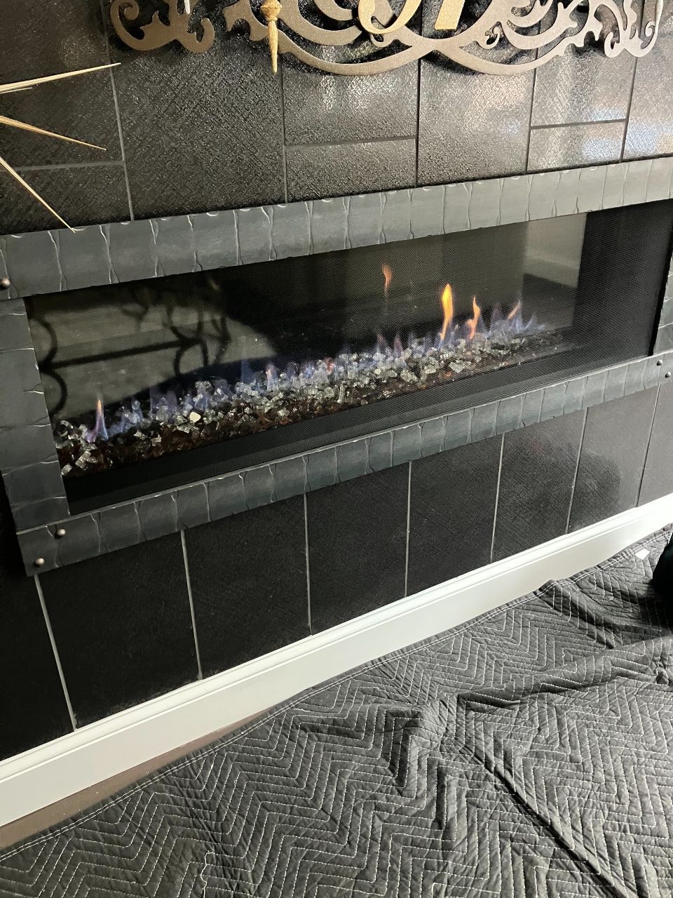A fireplace with flames coming out of it is being installed in a living room.