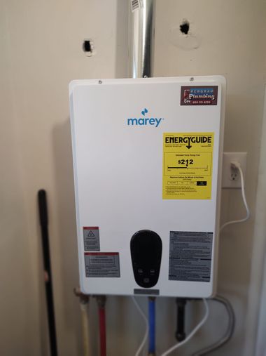 Marey tankless water heater mounted on a white wall, with energy guide sticker and water pipes below.