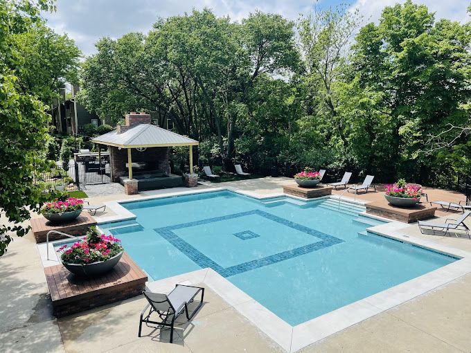 A large swimming pool surrounded by trees and chairs