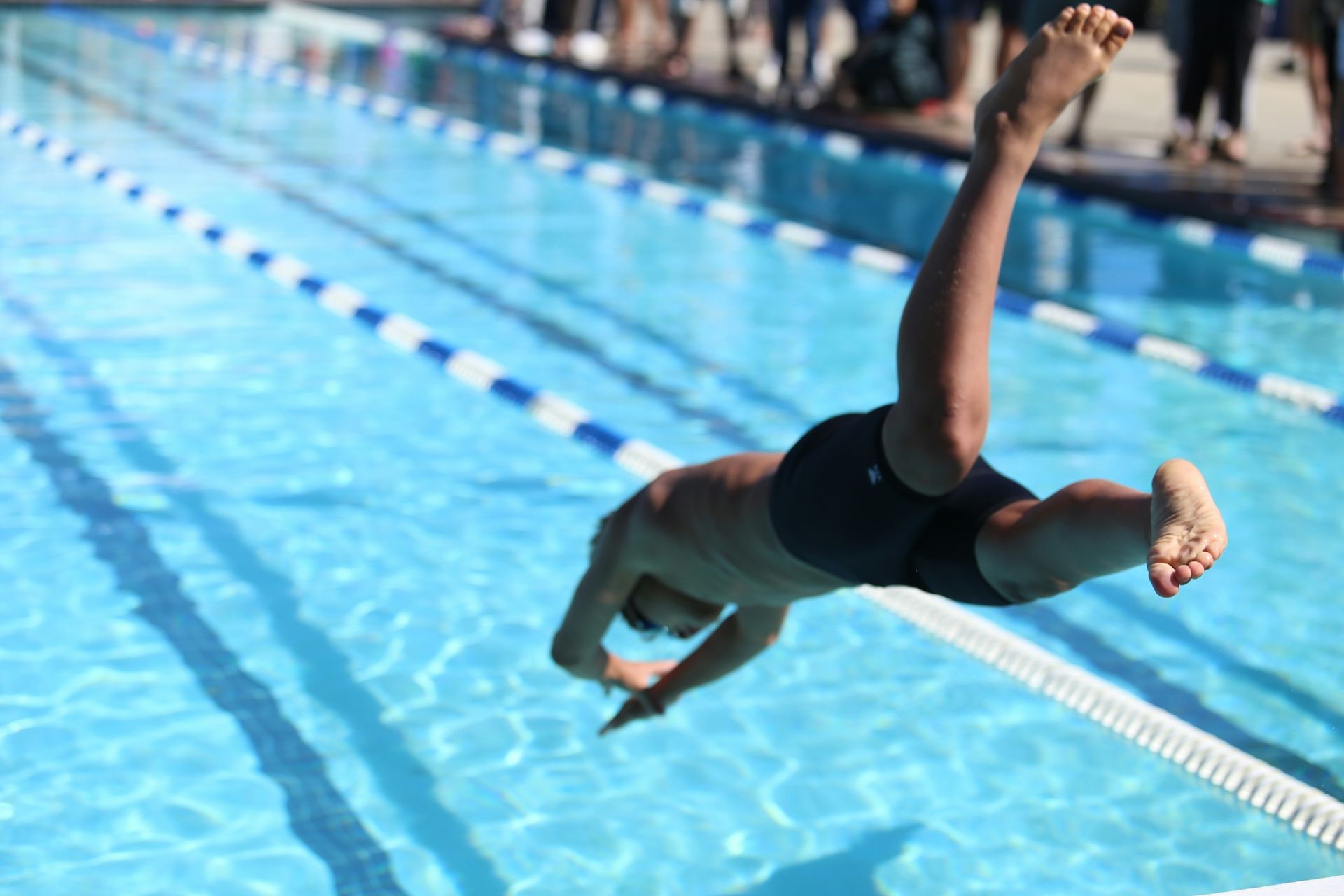 A man is diving into a swimming pool.