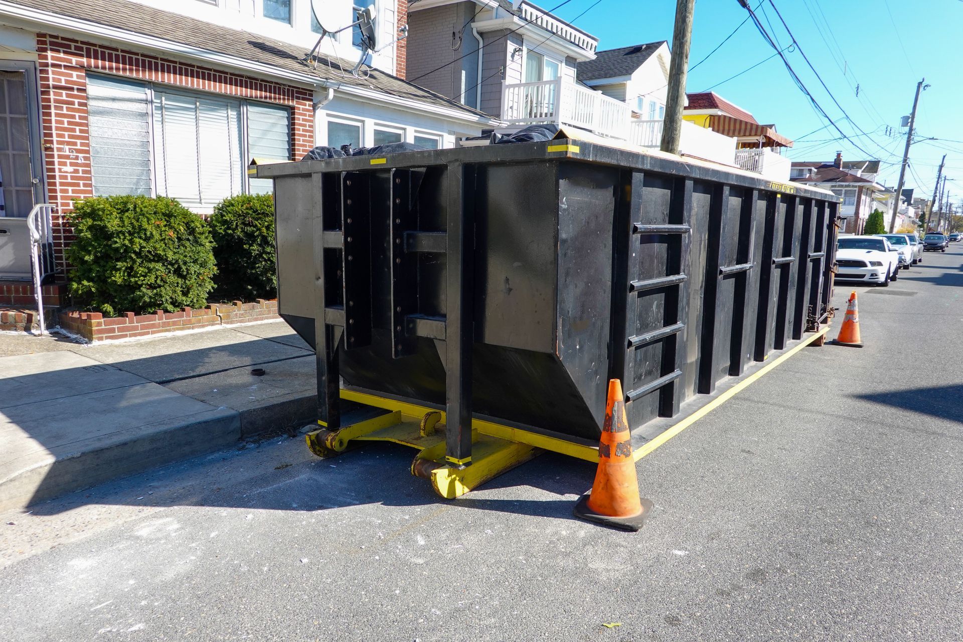 Roll-off dumpster parked on a suburban street for convenient residential dumpster rental.