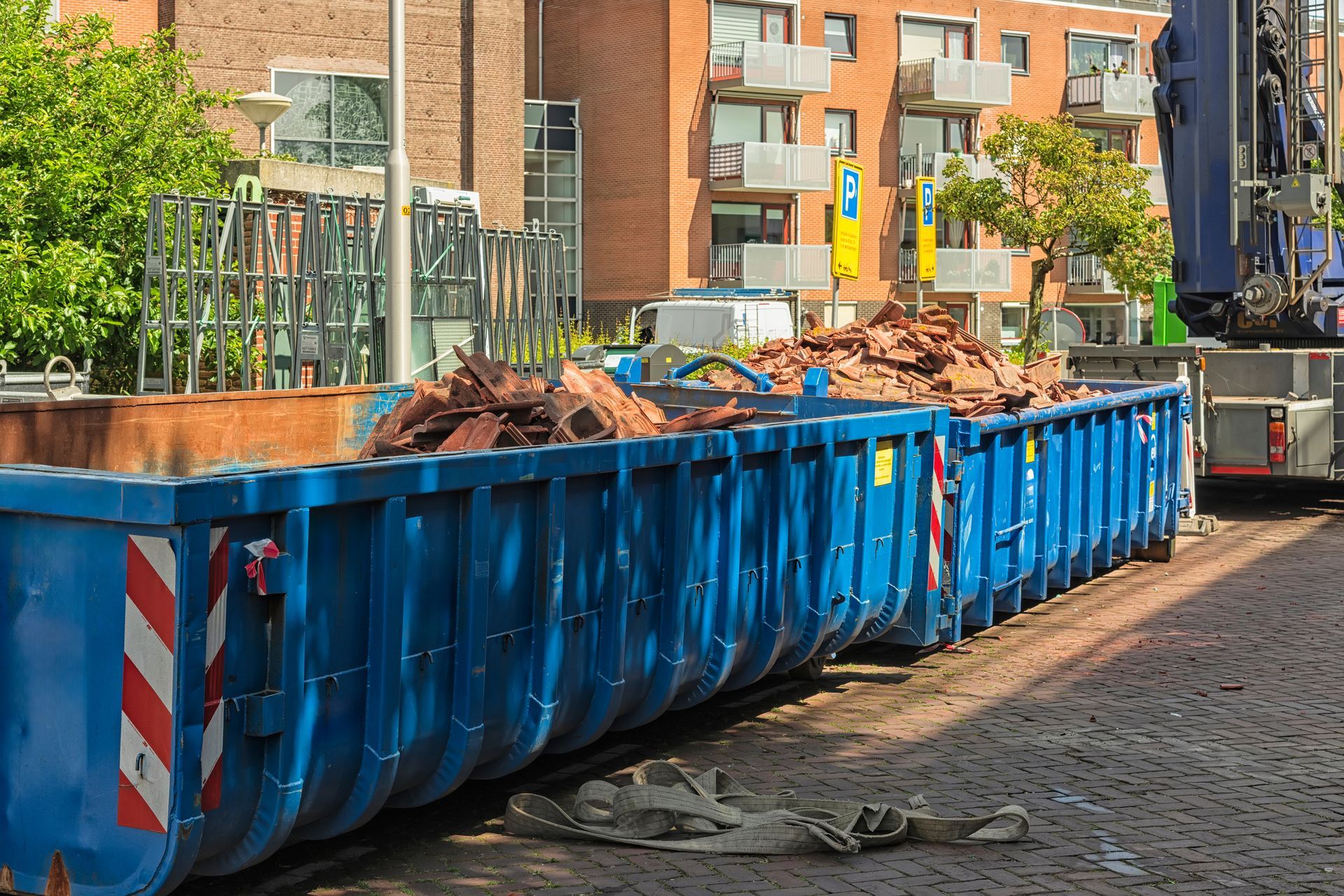 Long blue steel open industrial waste containers.