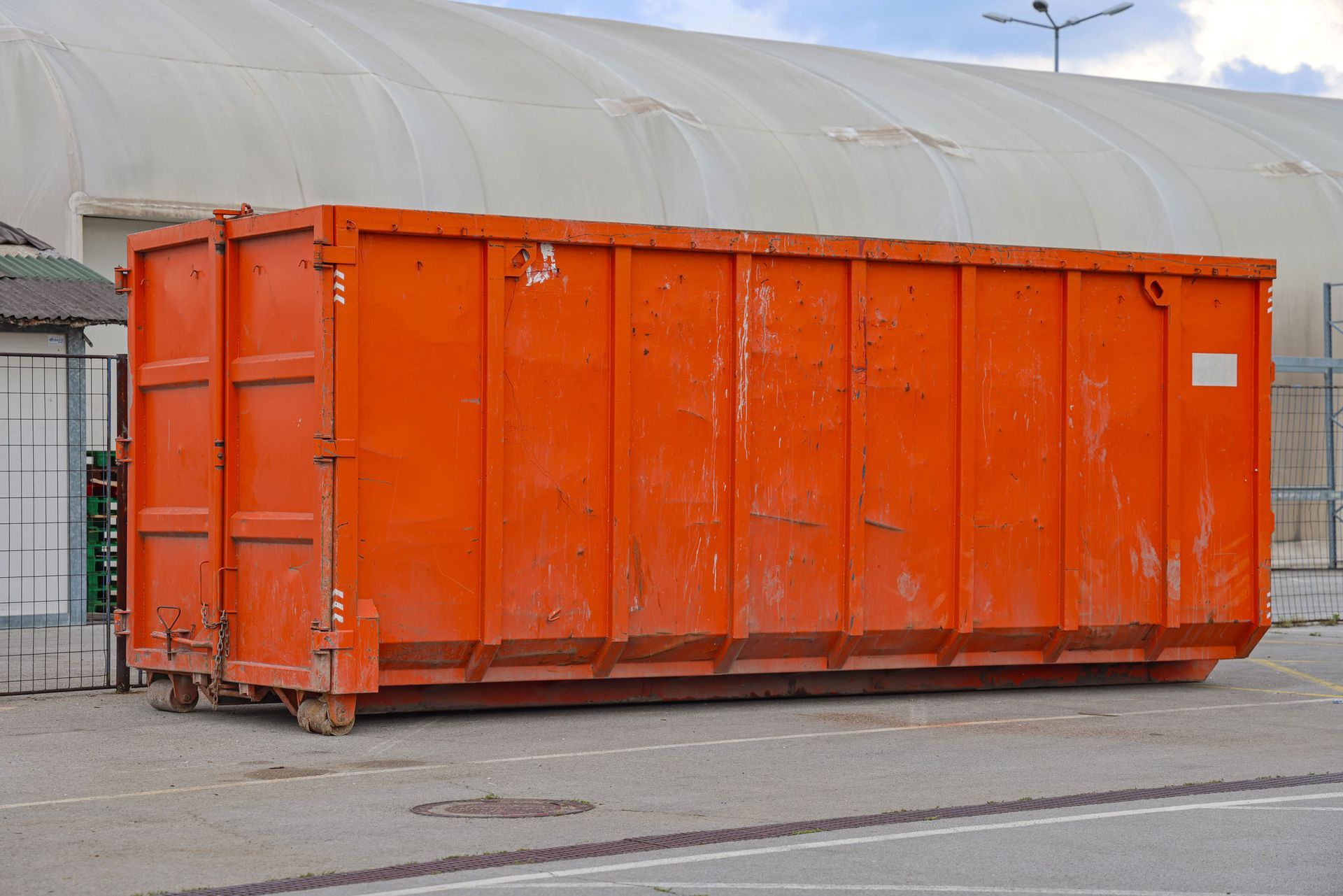 View of a large orange roll-off dumpster from L&R Dumpsters, showcasing industrial waste management