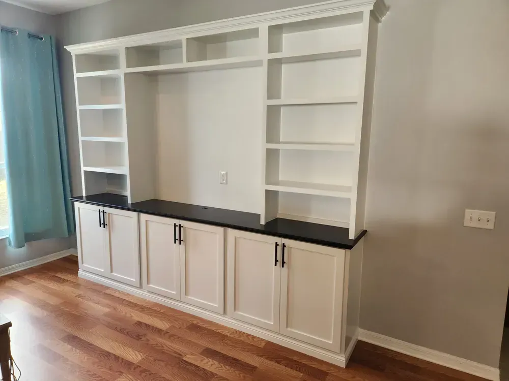 There is a large entertainment center in the middle of the room.