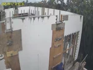 CCTV view of a white building under construction with exposed walls and scaffolding.