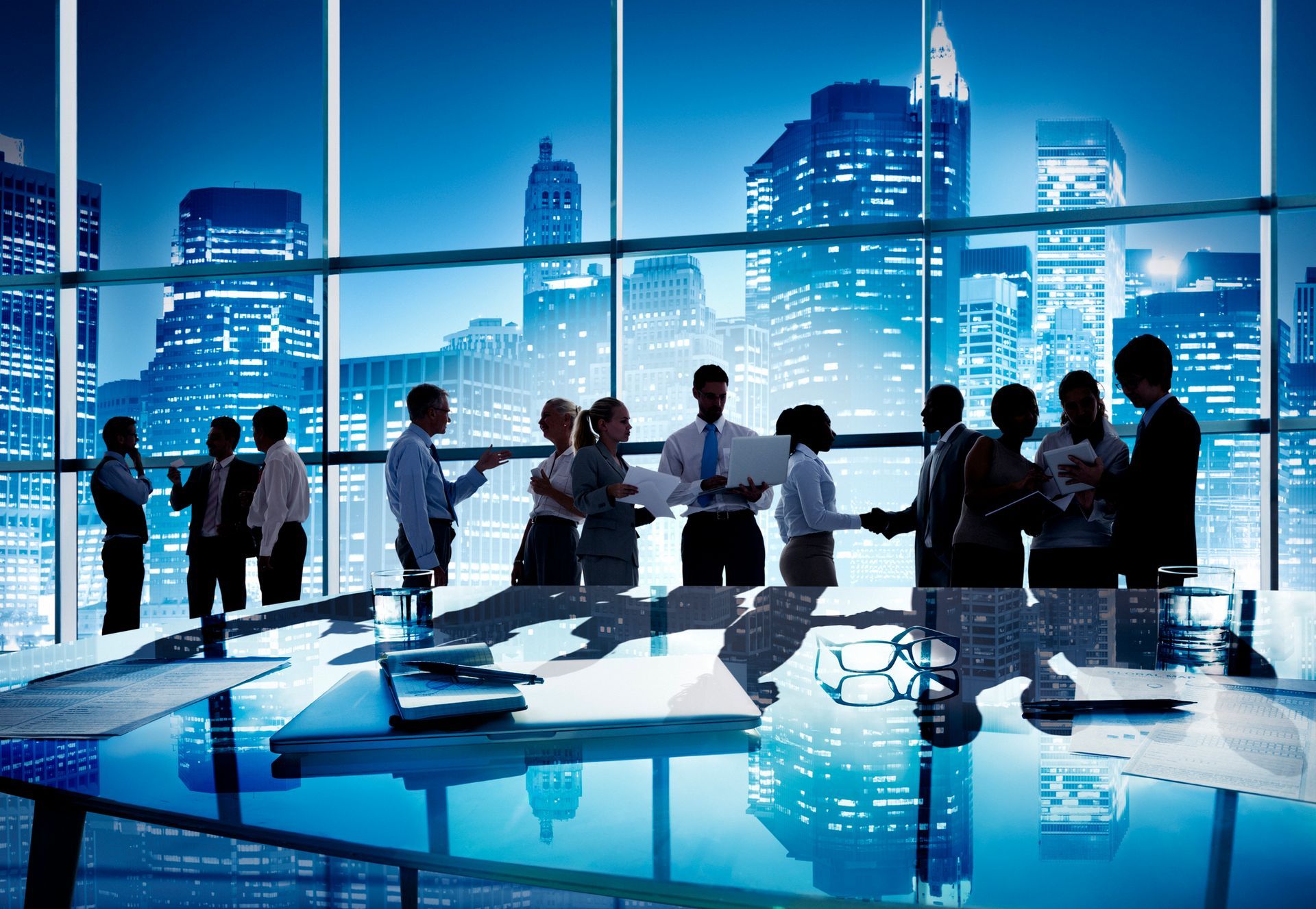 A group of business people are shaking hands in an office.
