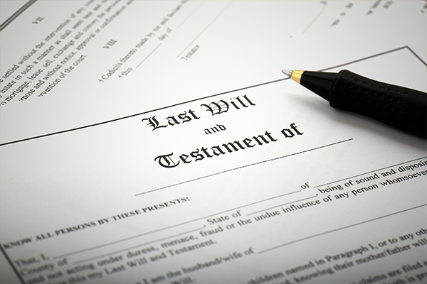 a pen is sitting on top of a last will and testament form