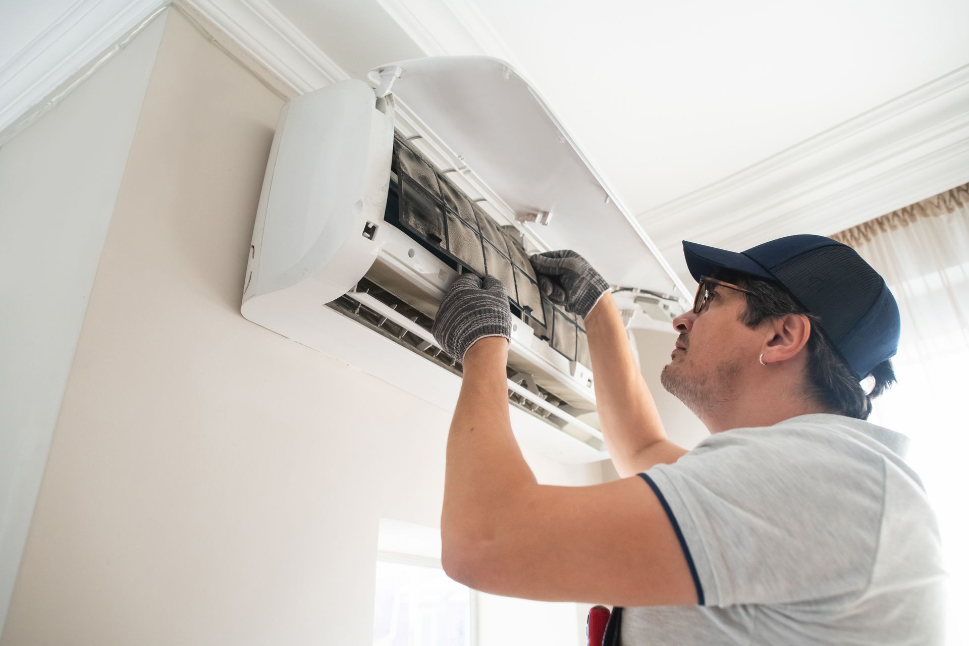 Technician doing air conditioner maintenance or repair as part of professional AC repair service. Technician doing air conditioner maintenance or repair as part of professional AC repair service.