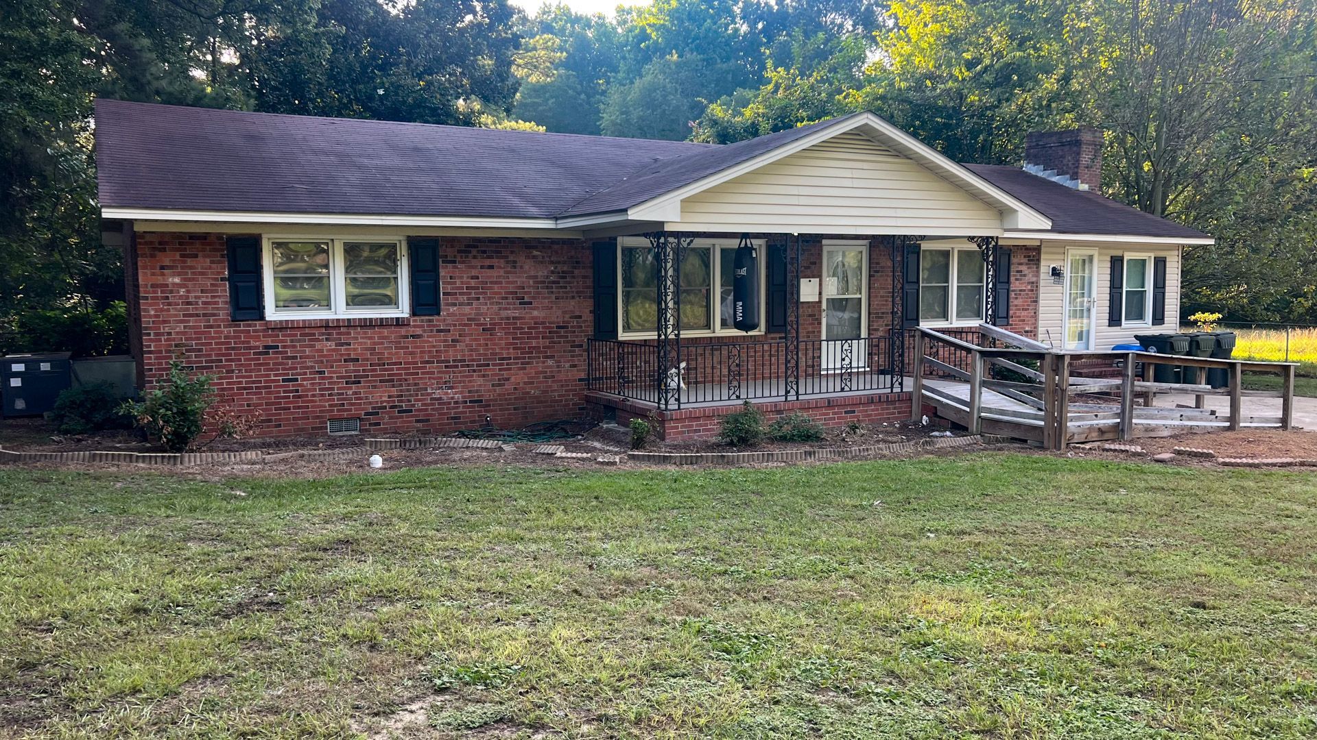 A brick house with a large lawn in front of it.