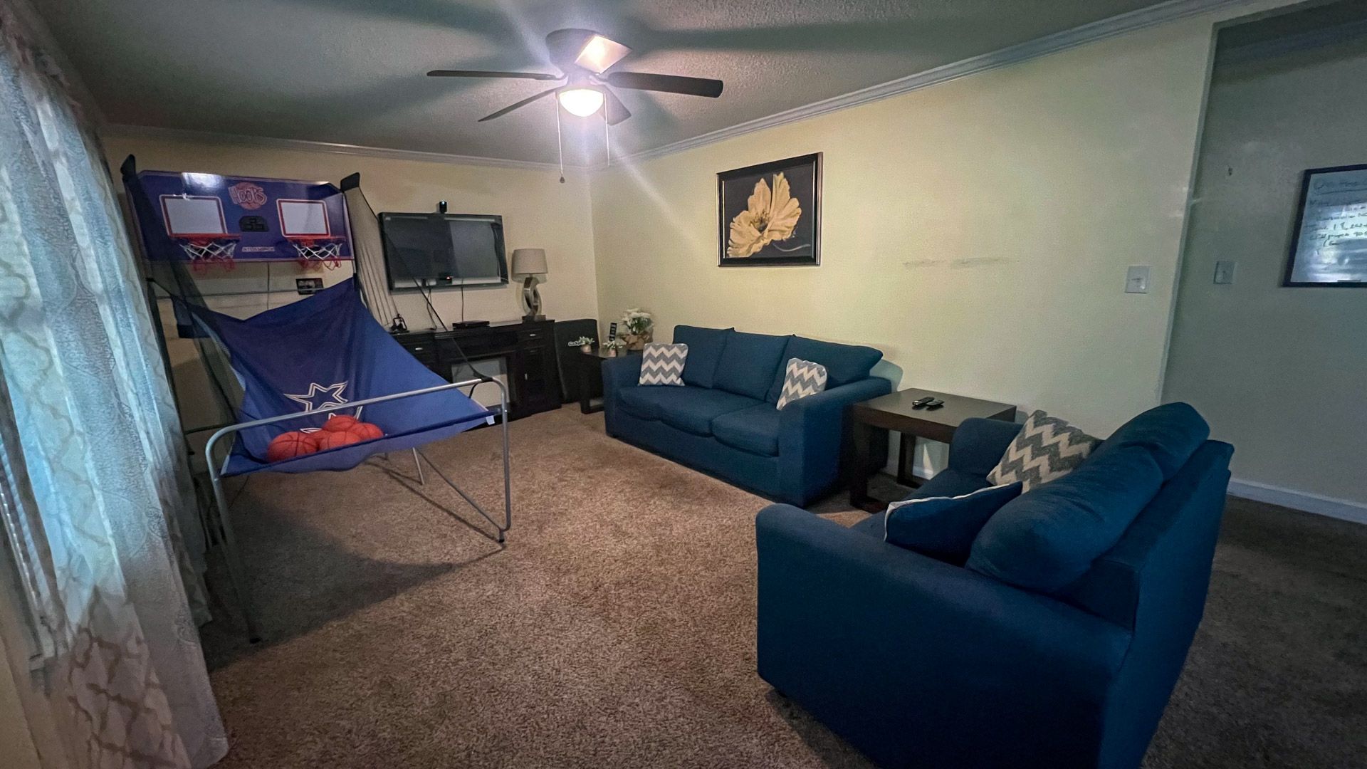 A living room with a couch , chairs , and a ceiling fan.