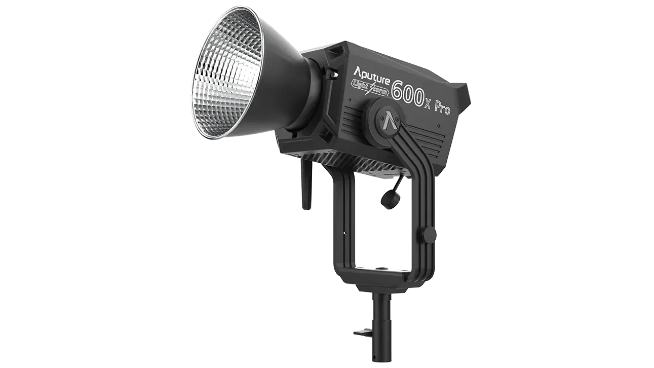 Black studio spotlight with silver reflector on a stand against a white background