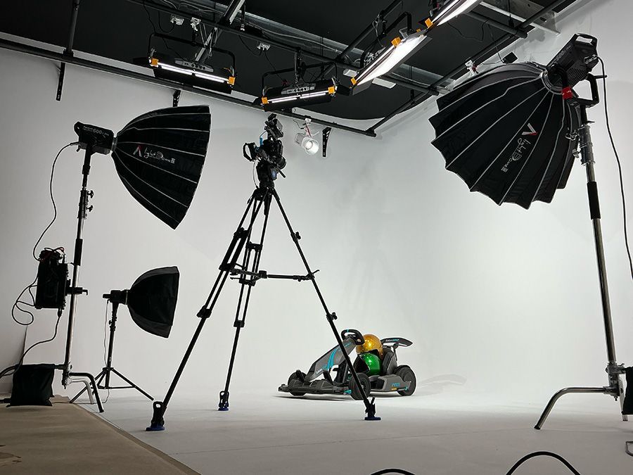 Professional photo studio with lights, tripods, and a camera in front of a white backdrop