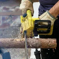Person applying gray plaster to a wall with two trowels.