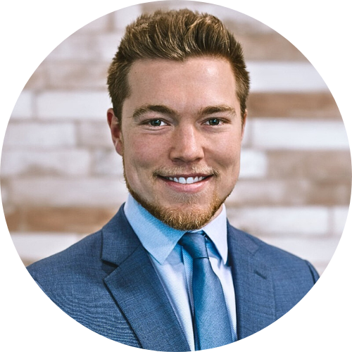 A man in a suit and blue shirt smiles for the camera