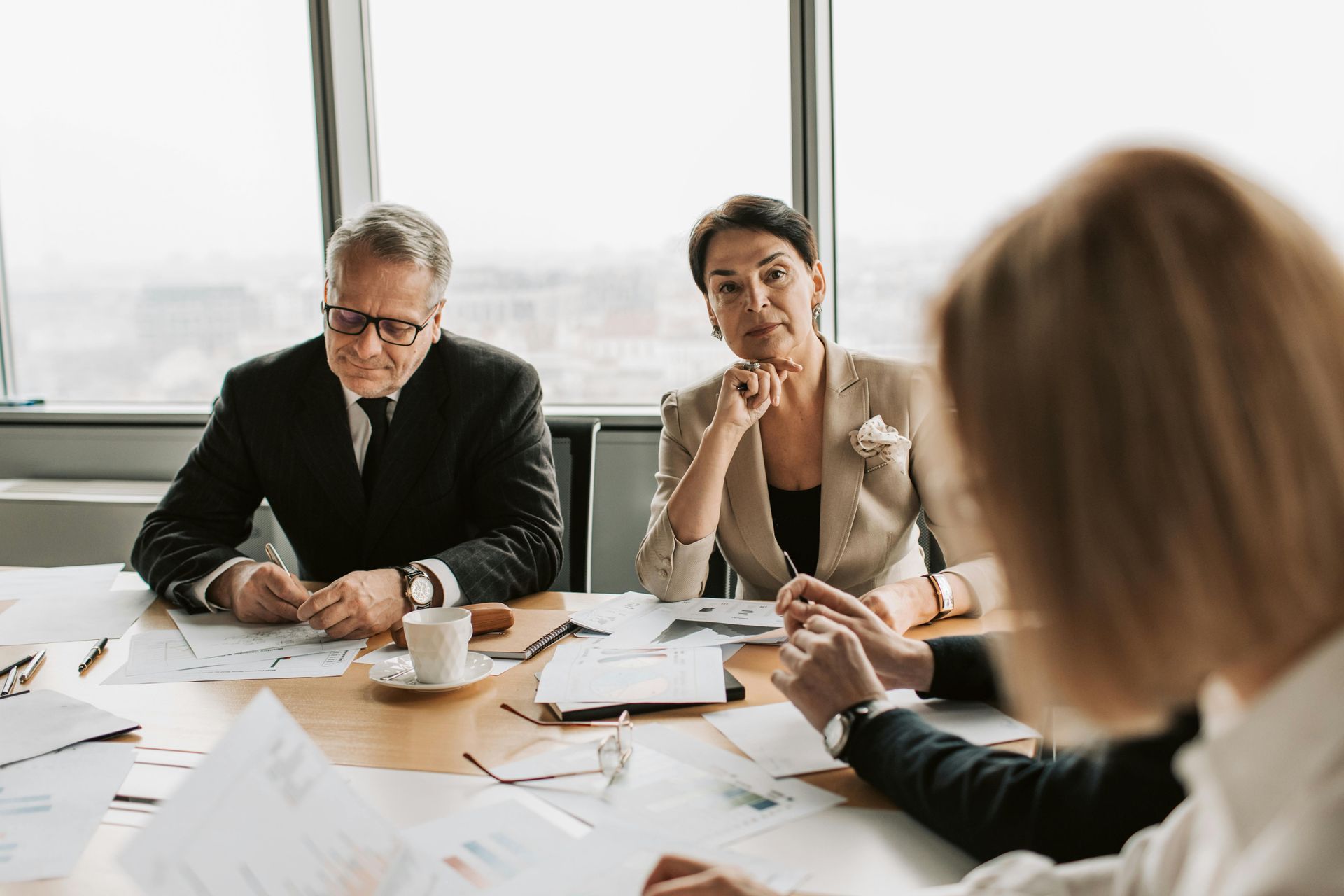 A group of business people are sitting around a table having a meeting.