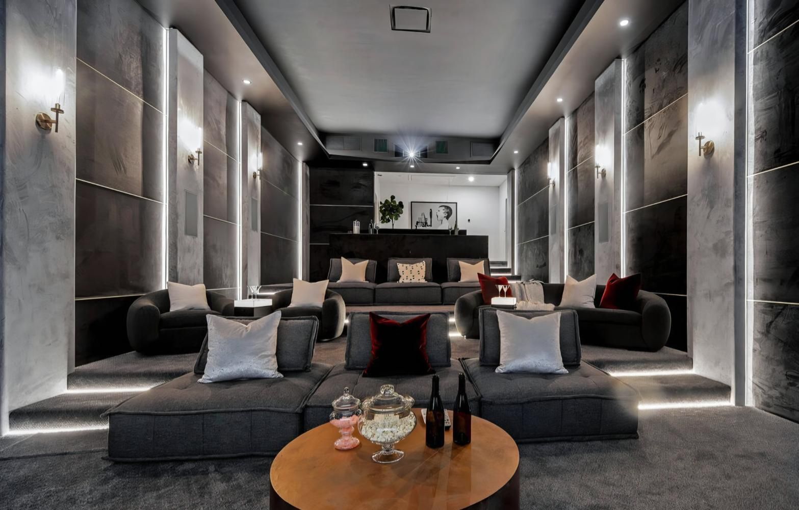 Luxurious dark gray lounge with sofas, a round coffee table, and modern wall lighting