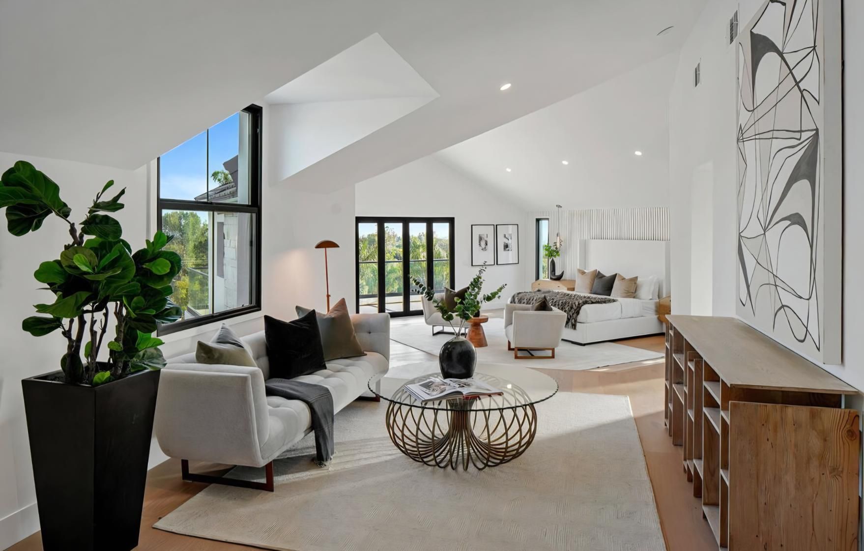 Bright modern living room with white walls, gray sofas, wood accents, and large windows
