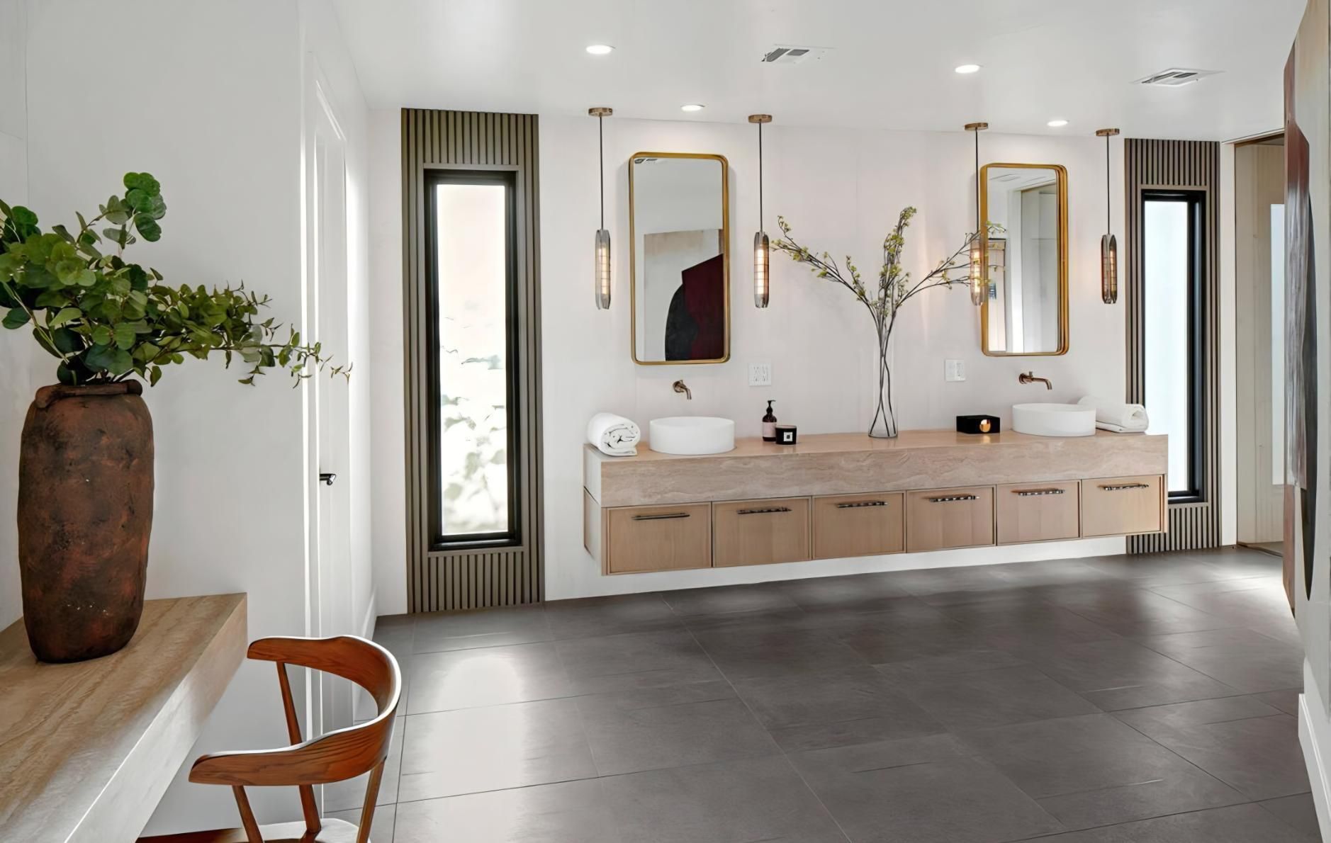 Modern minimalist bathroom with double sinks, round mirrors, wood vanity, and large windows