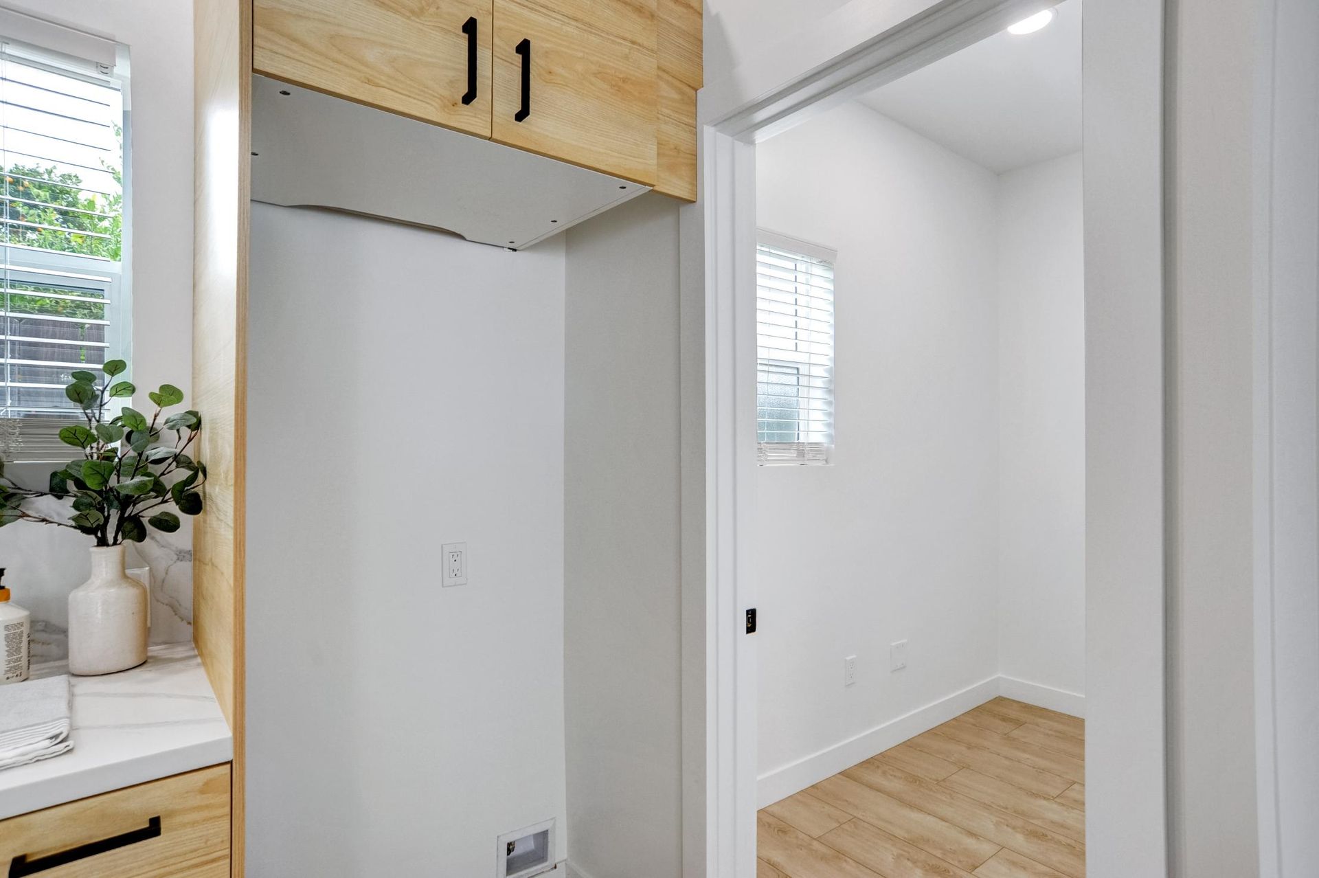 Modern walk-in closet with wood accents, white walls, and a doorway labeled 11