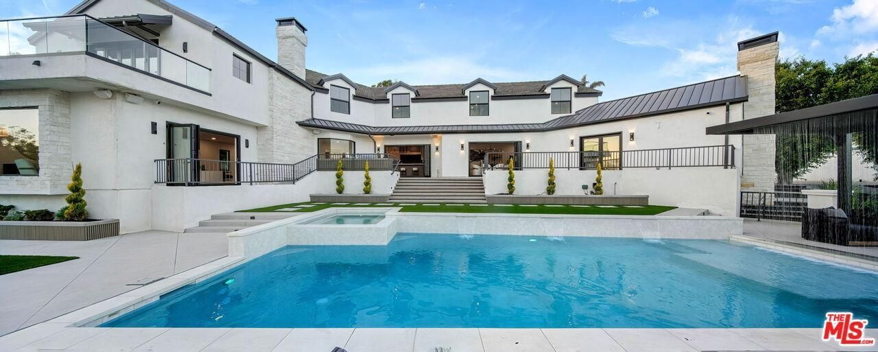 Modern white house courtyard with a blue swimming pool and patio seating