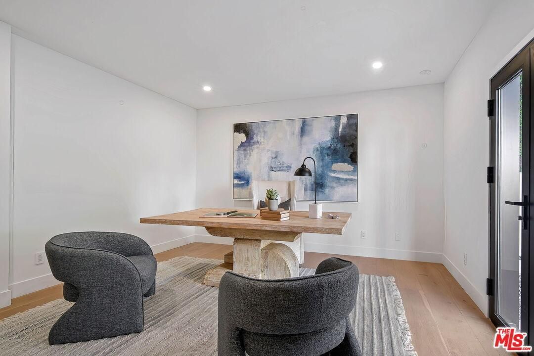 Bright modern dining room with wood table, gray chairs, abstract wall art, and white walls.