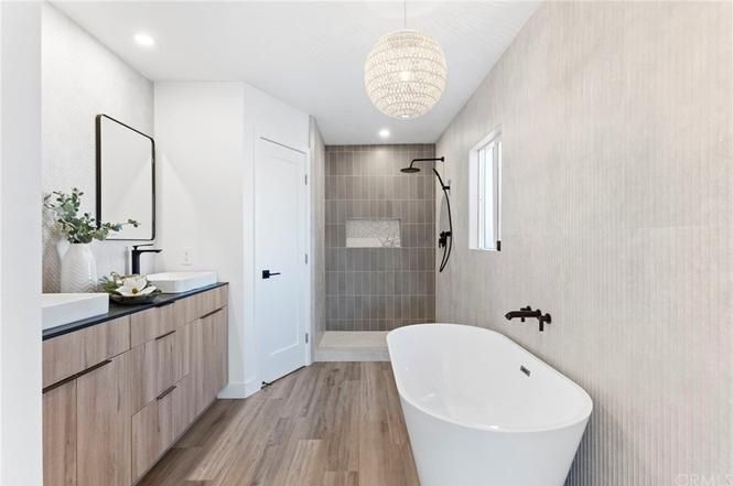 Modern bathroom with freestanding tub, wood vanity, walk-in shower, and white walls