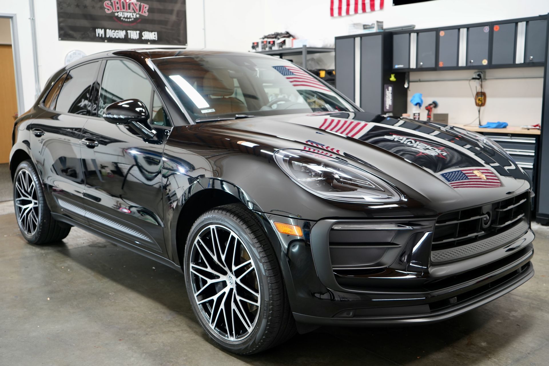 A black porsche macan turbo is parked in a garage.