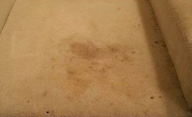 Close-up of a beige surface with a faint brown stain in the center