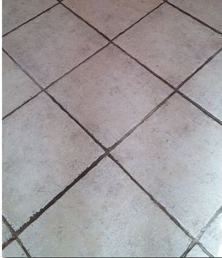 Beige tiled floor with dark grout lines, viewed from above.