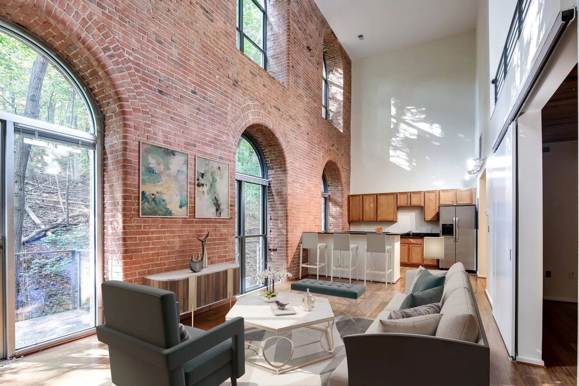 a living room with a couch and chairs and a kitchen