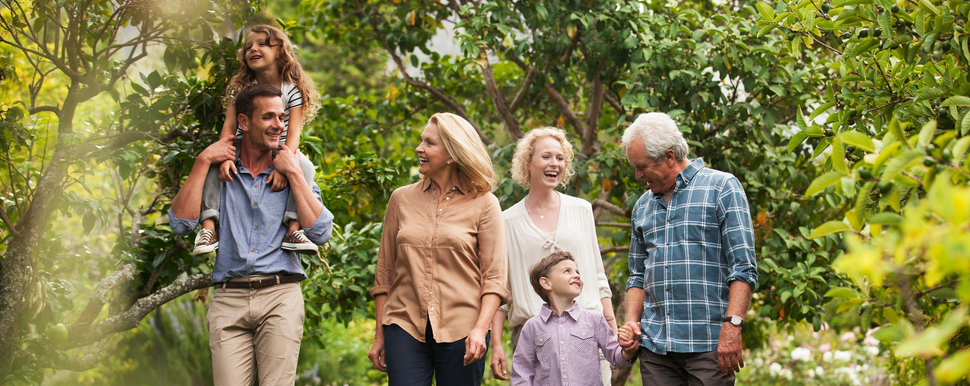 Family walking together in a lush green garden, smiling and relaxed