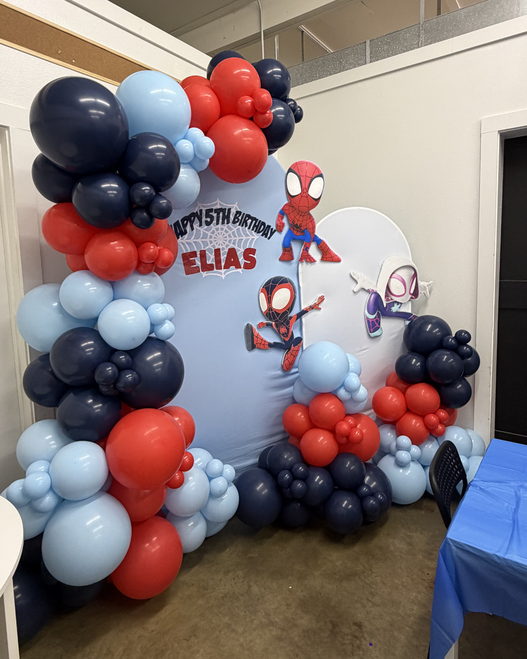 Spider-Man balloon display in red, blue, and black with the name Elias at a party booth backdrop