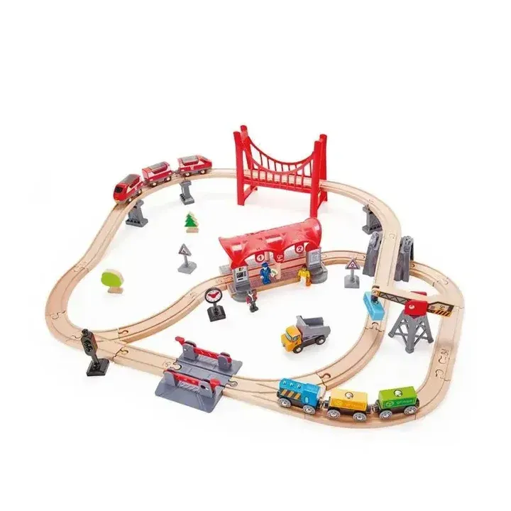Wooden toy train set with red bridge, multiple trains, and track accessories on a white background
