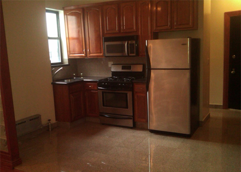 Kitchen with brown cabinets, stainless steel appliances, and a window.
