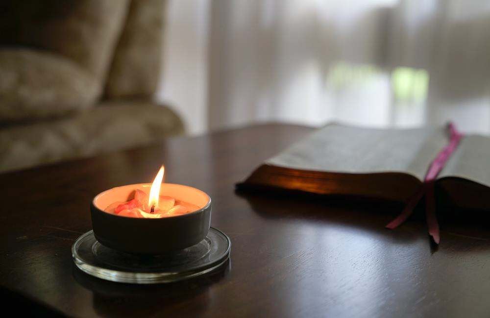 A Candle on a Table Beside a Bible During a Christian Counselling Session — Family Counselling in Dubbo, NSW