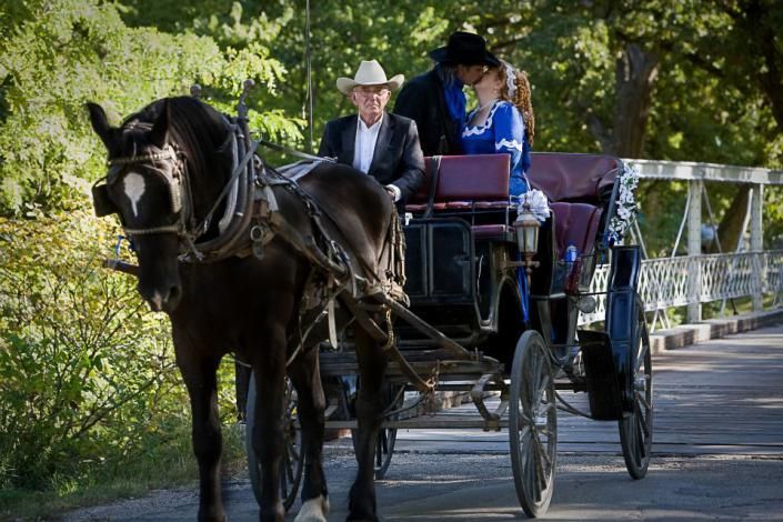 couple kissing on horse drawn carriage