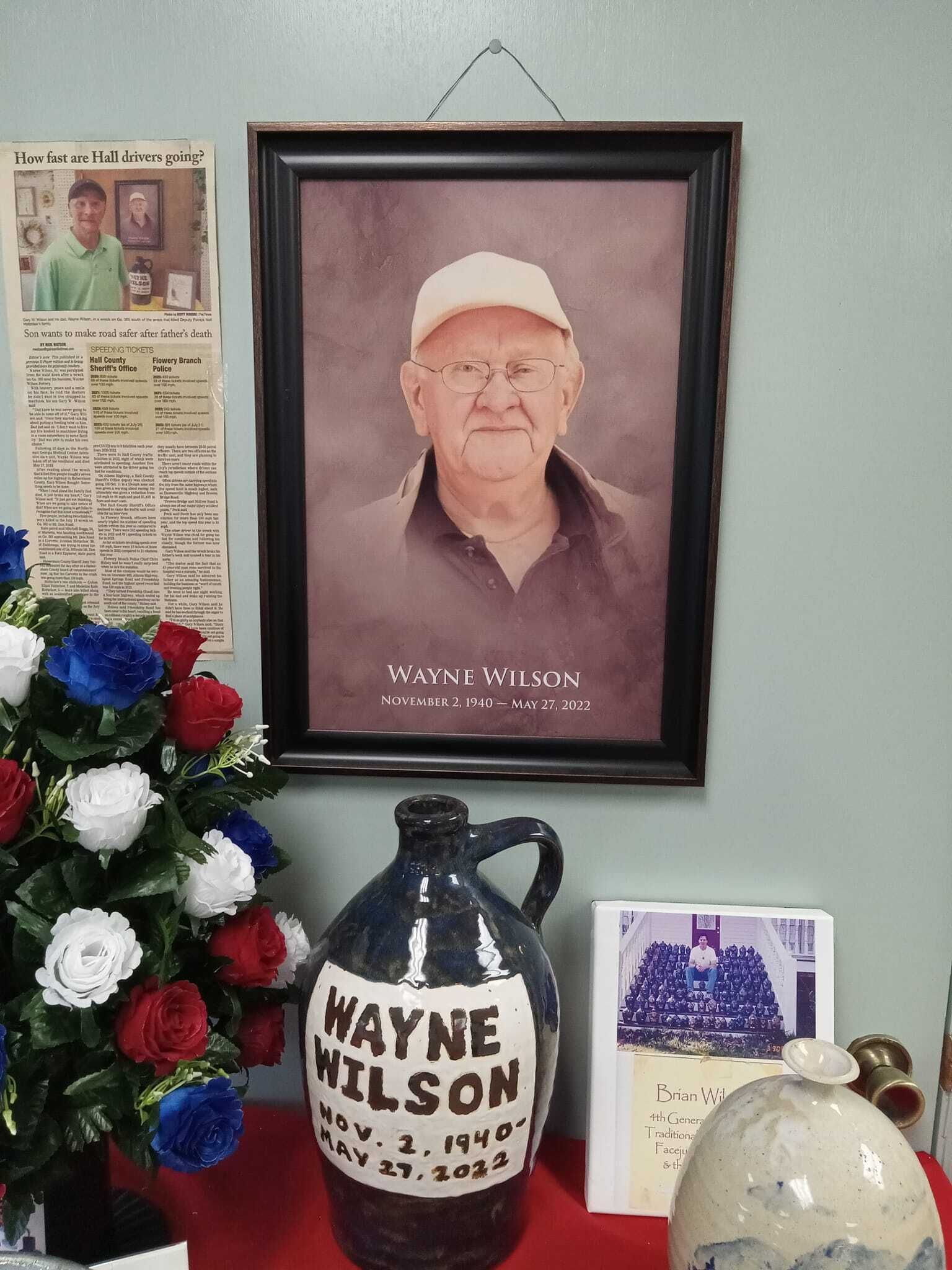A picture of wayne wilson hangs above a pitcher