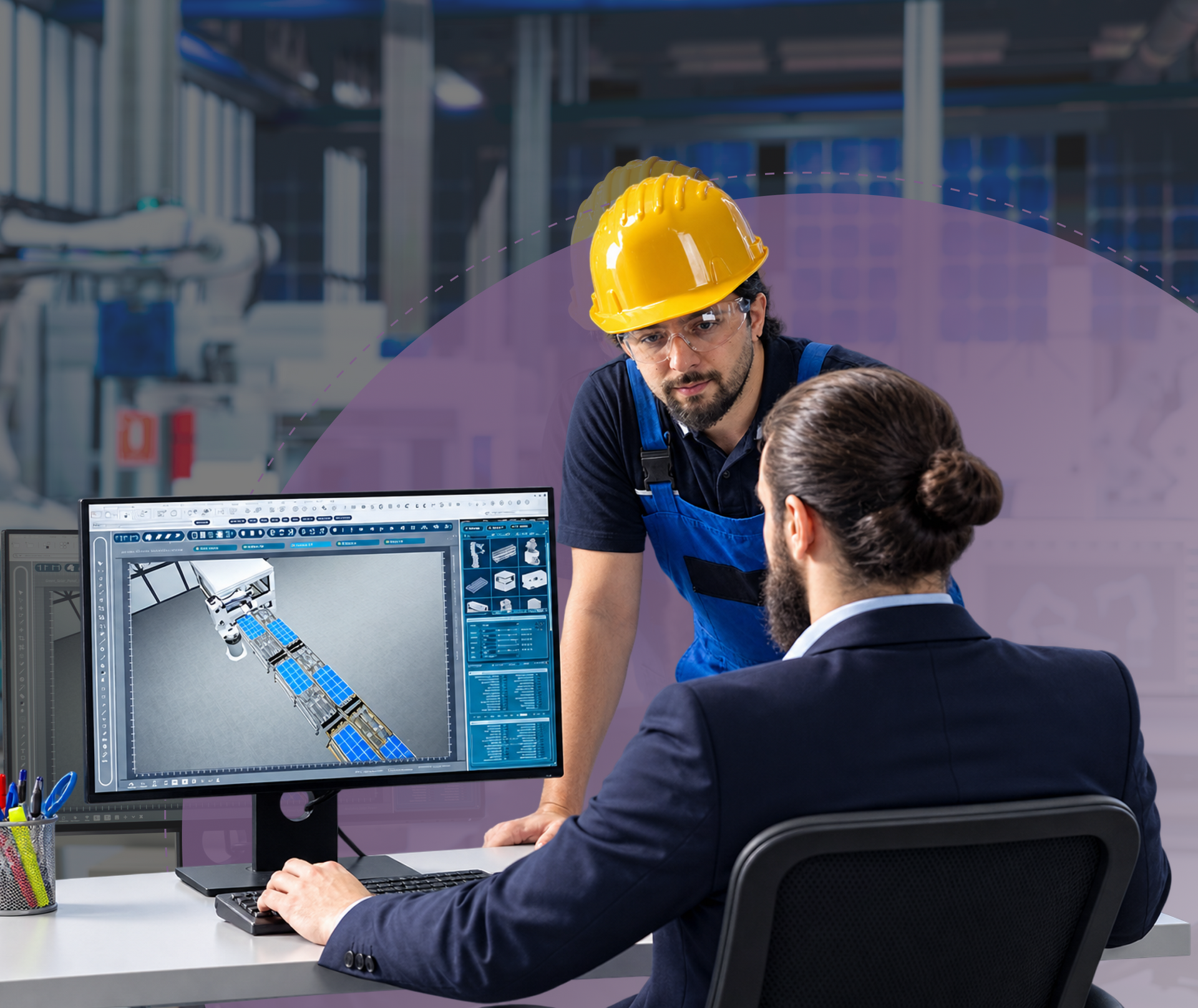 Engineer and colleague reviewing a 3D mechanical model on a computer in an industrial workshop