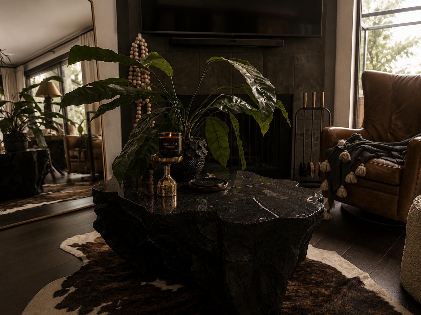 Dim living room with dark coffee table, potted plant, and fireplace beside an armchair.