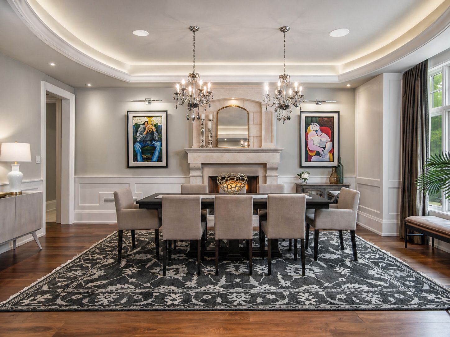 Elegant dining room with chandelier, fireplace, framed art, and large rug