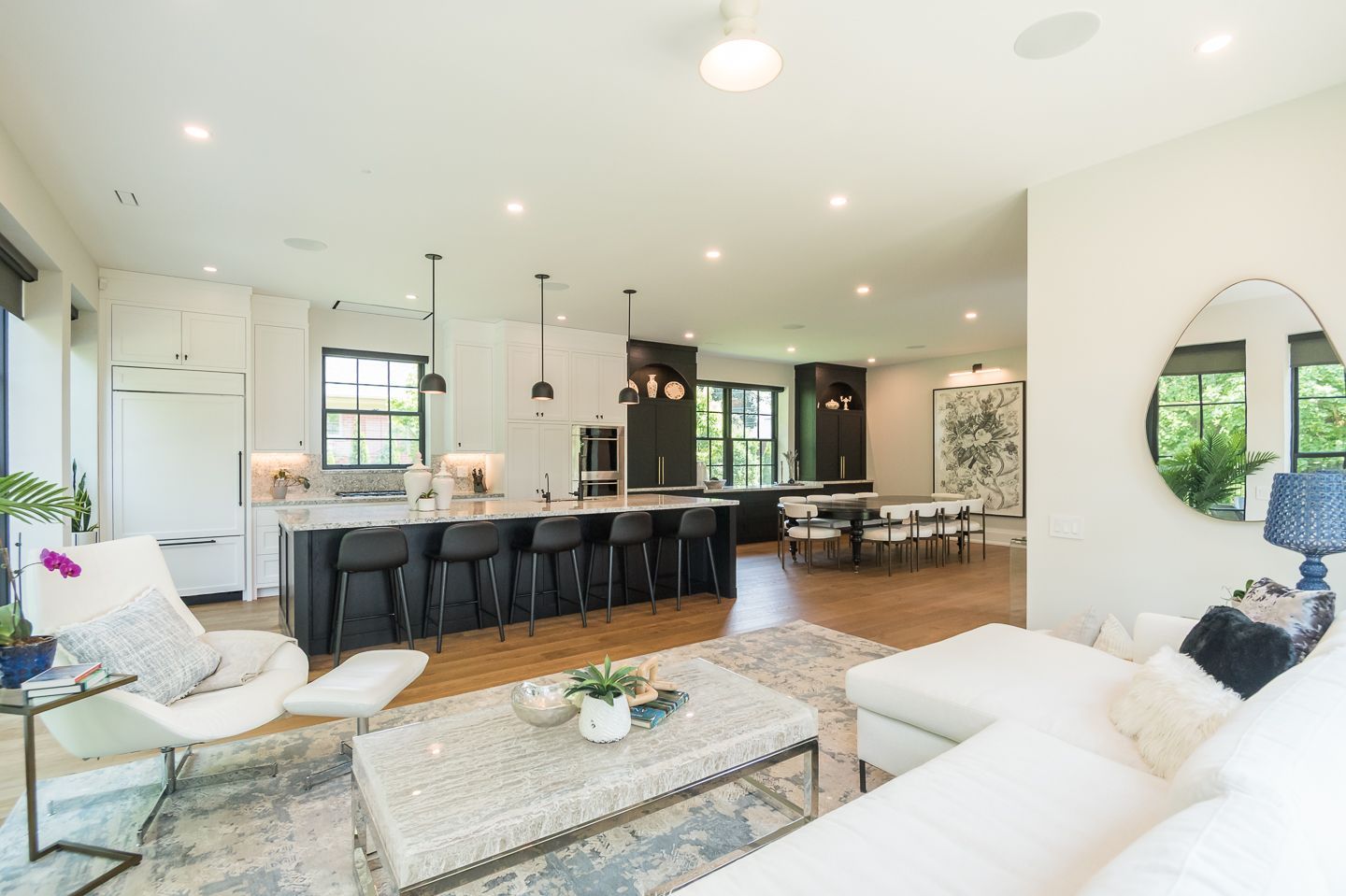 A living room with a couch , chair , coffee table and mirror.