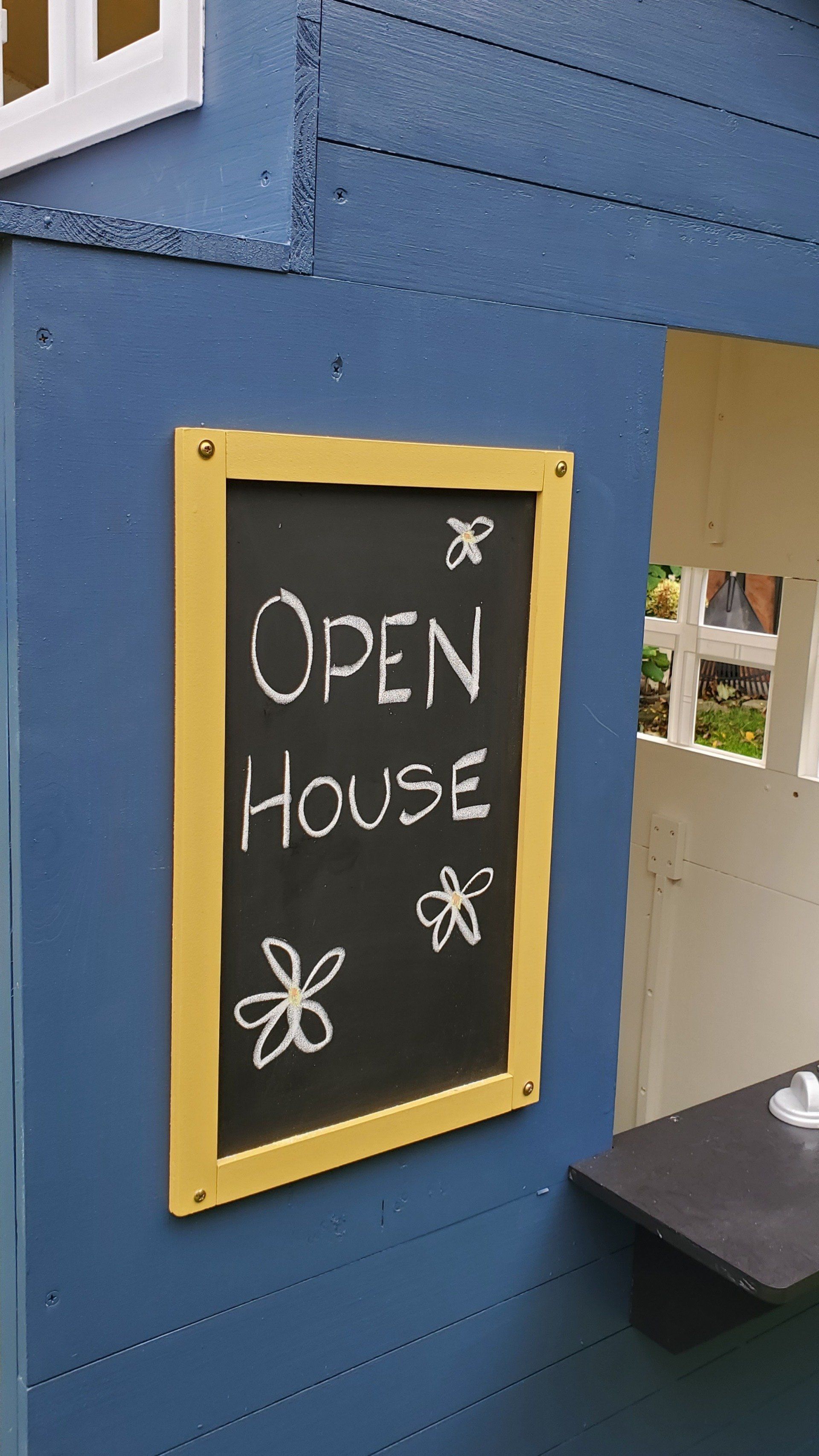 A chalkboard with the words open house written on it