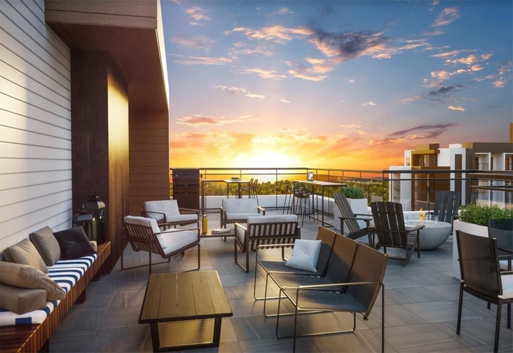 Rooftop patio with seating, fire pit, and sunset view.